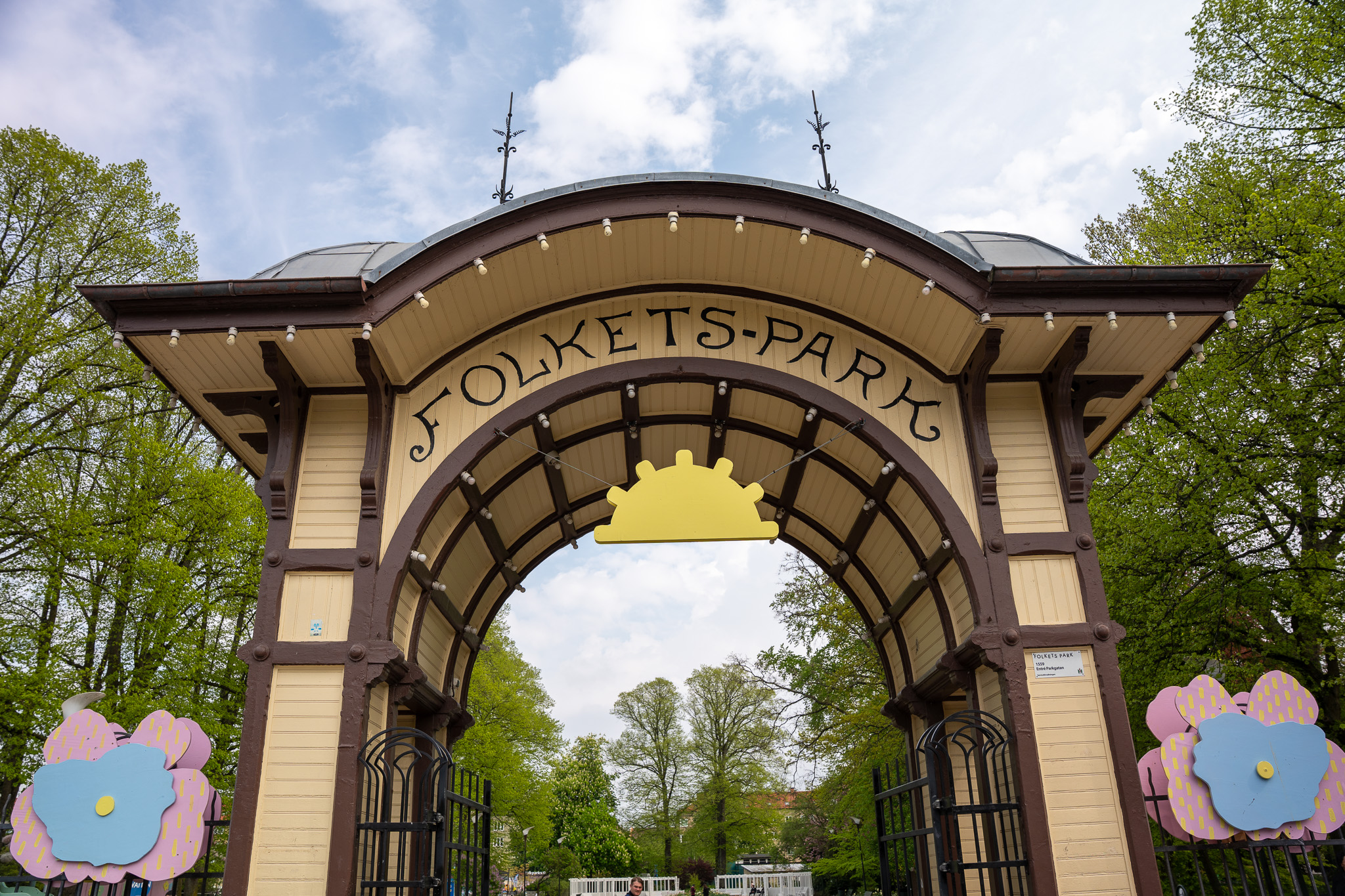 Verzierter hölzerner Eingangsbogen des Folkets Park in Malmö mit geschwungenem Schriftzug