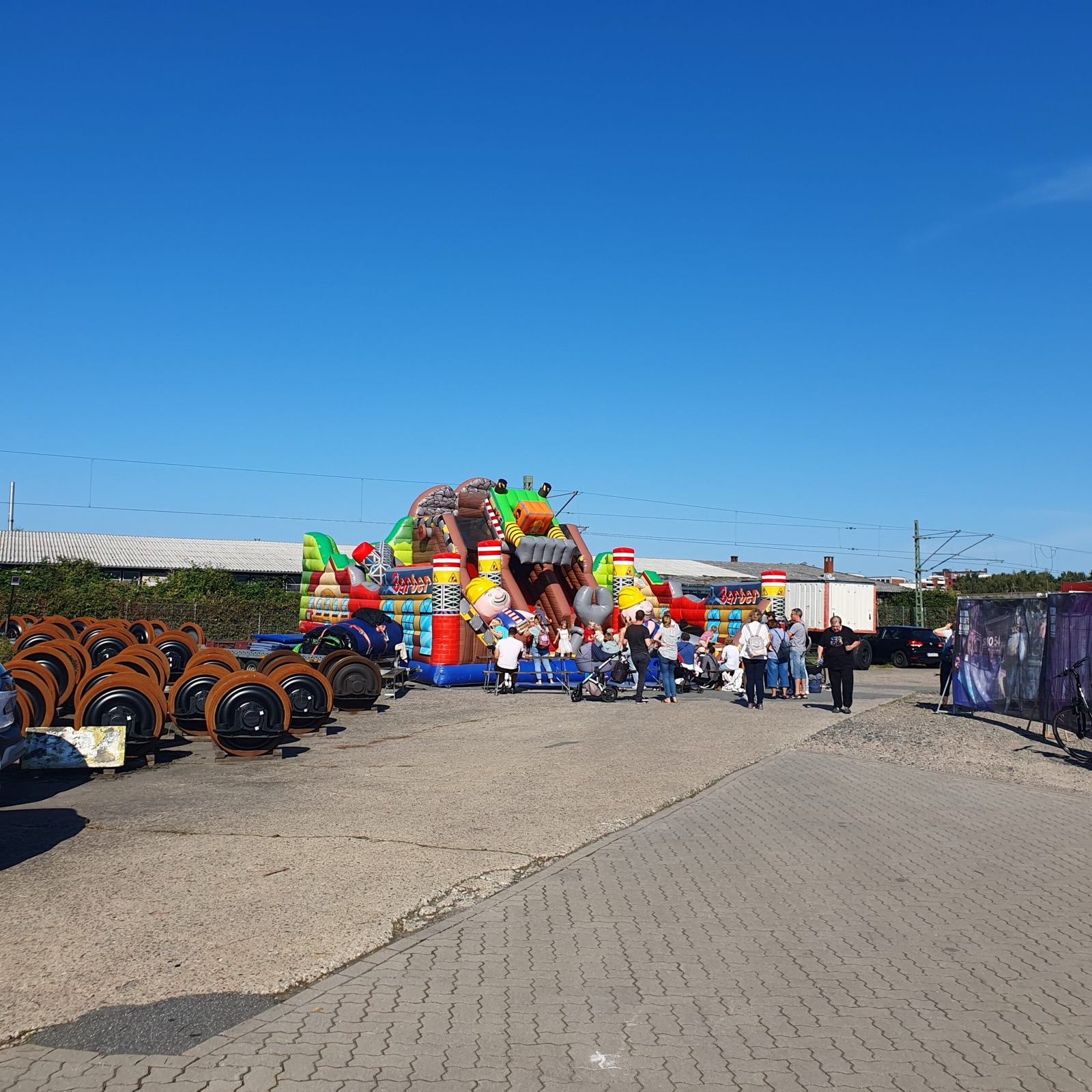Festgelände mit Hüpfburg und gelagerten Radsätzen im Vordergrund