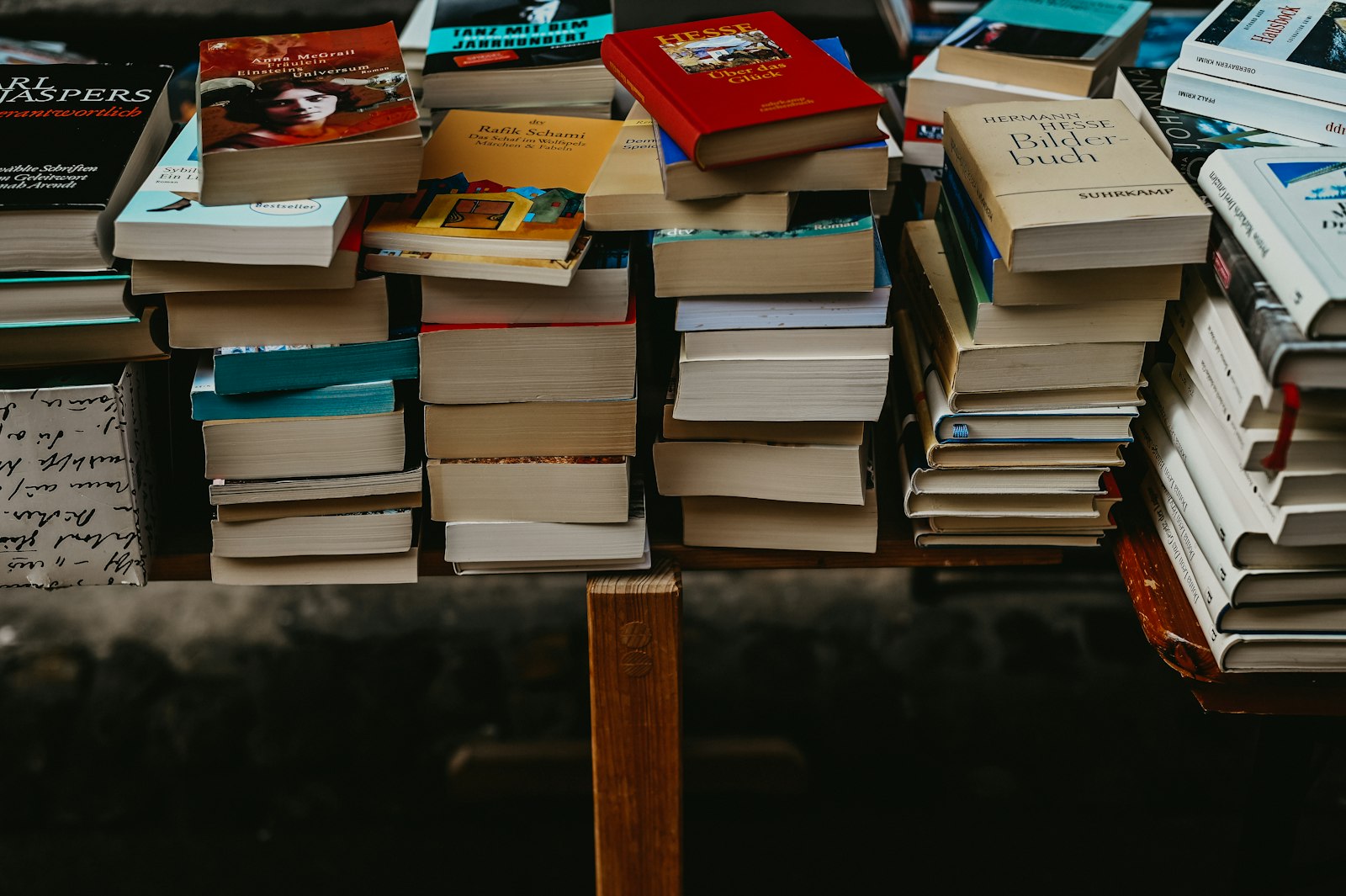Stapel gebrauchter Bücher auf einem Holztisch