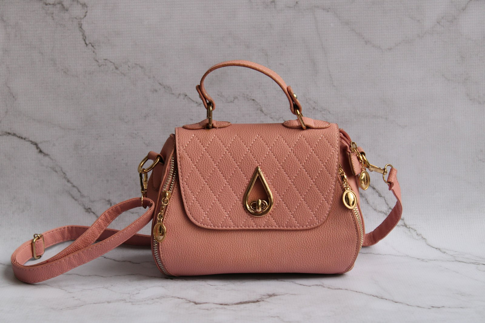 Rosa Handtasche auf einer Marmorplatte