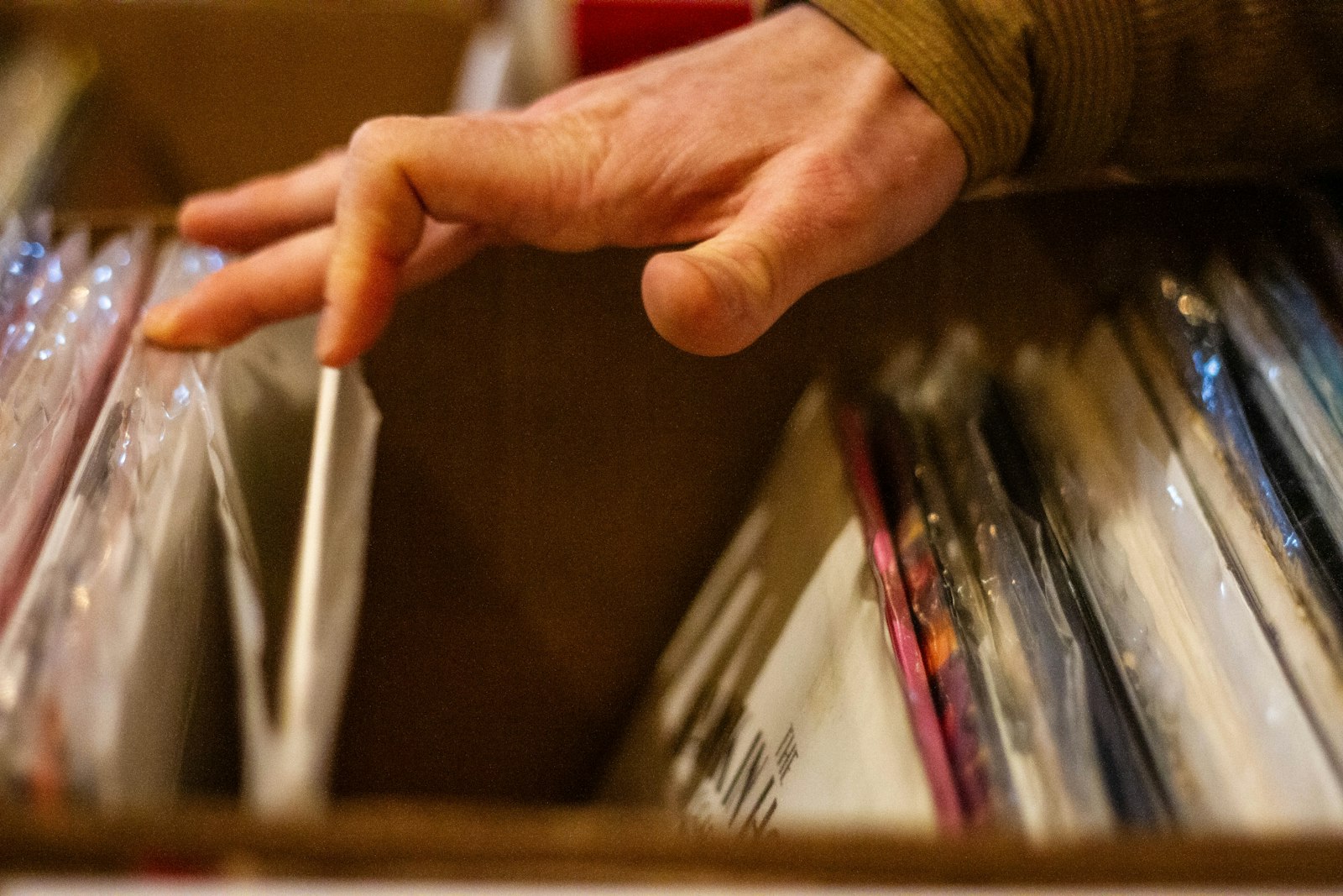 Hand stöbert durch eine Kiste mit Schallplatten