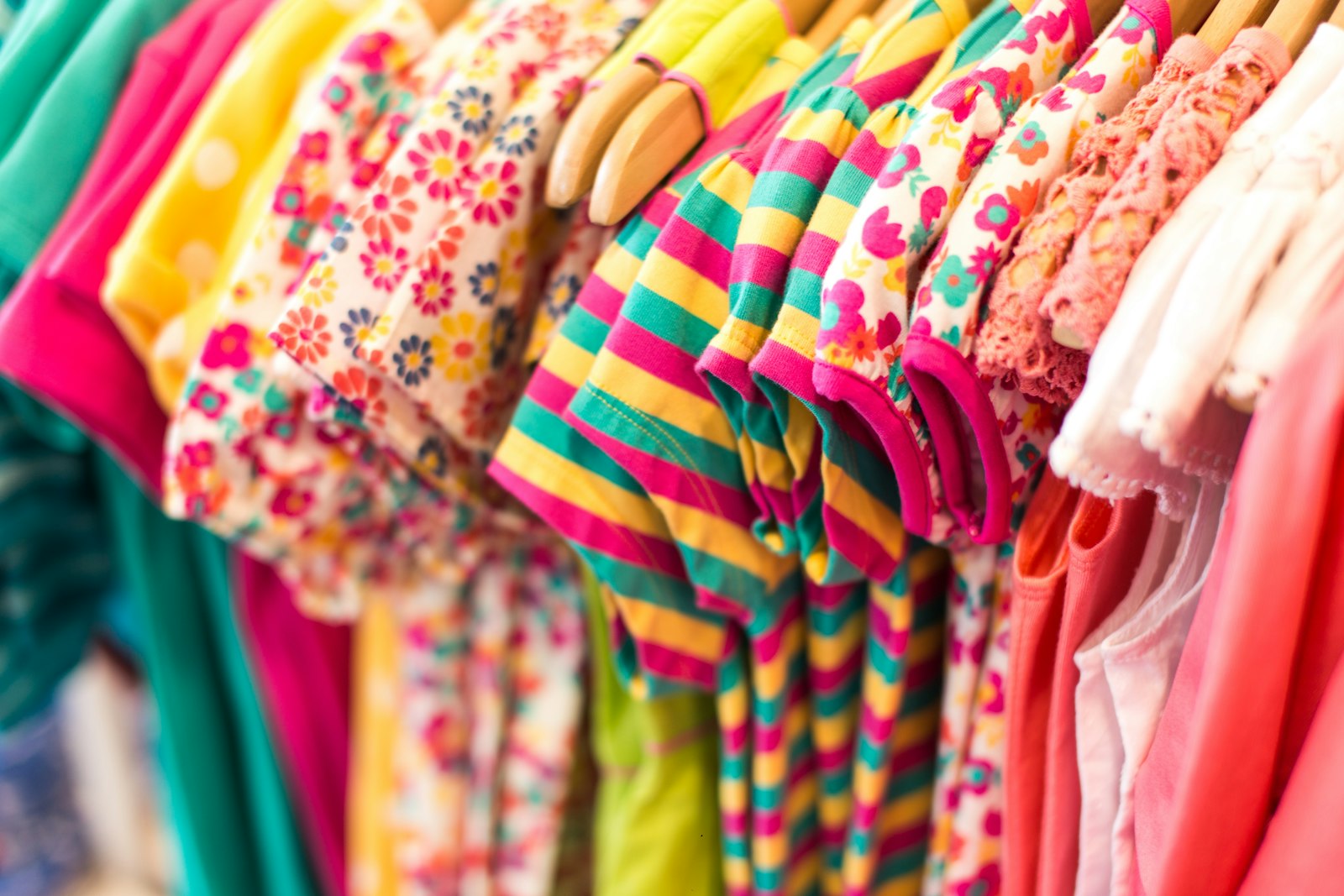 Bunte Kinderkleidung auf Bügeln